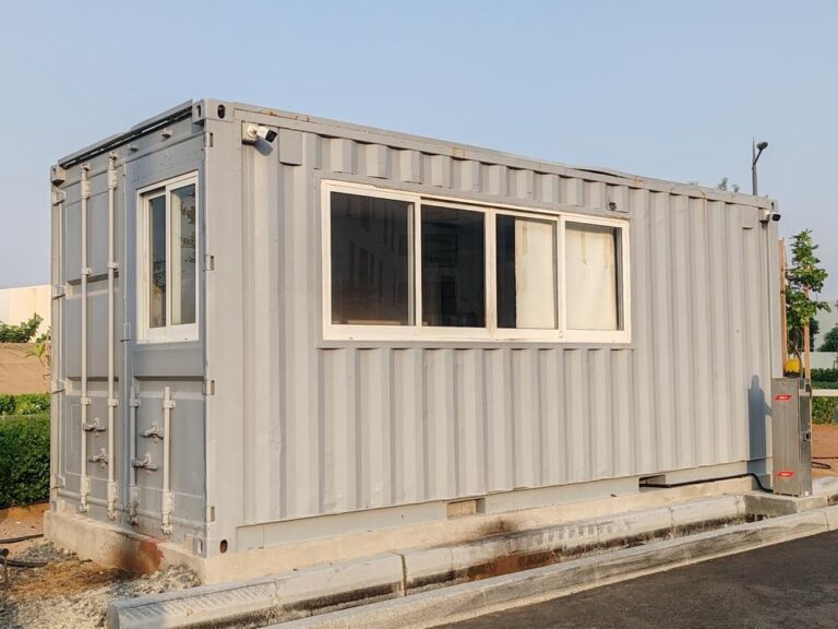 Grey portable cabin placed on an active construction site.
